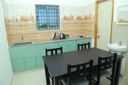 a kitchen with a black table and a sink at Ameya Homestays Brand New Fully Furnished 3BHK & 2BHK Apartments. in Tirupati