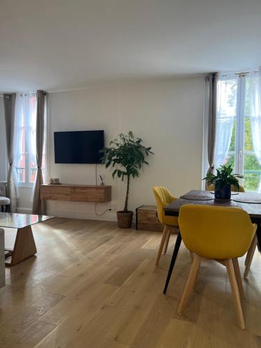 salon ze stołem i żółtymi krzesłami w obiekcie Appartement moderne en plein centre D'Epernay w Épernay