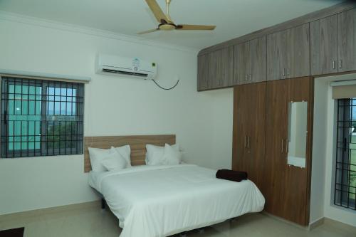 a bedroom with a white bed and a ceiling at Ameya Homestays Brand New Fully Furnished 3BHK & 2BHK Apartments. in Tirupati