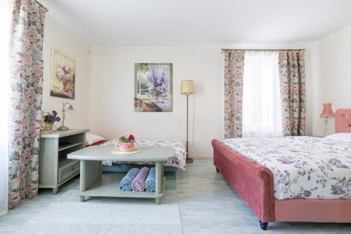 a bedroom with a bed and a table and curtains at Videviku Villa Apartments in Tallinn