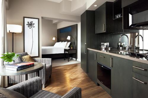 a living room with a kitchen and a dining room at One King West Hotel and Residence in Toronto