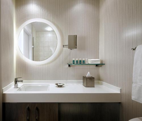 a bathroom with a sink and a mirror at One King West Hotel and Residence in Toronto