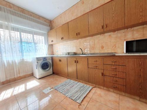 a kitchen with a sink and a washing machine at Lovely Two Bedroom Apartment in Amman in Umm Uthainah