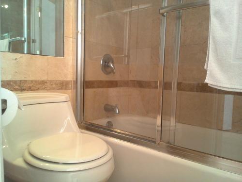 y baño con aseo y ducha. en El Rancho Motel en San Diego