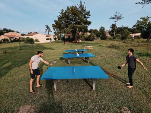 dos hombres jugando al ping pong en una mesa en Pinea Mare en Poggio-Mezzana