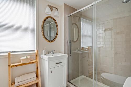 a bathroom with a shower and a sink and a mirror at Sunroom on Maple in Picton
