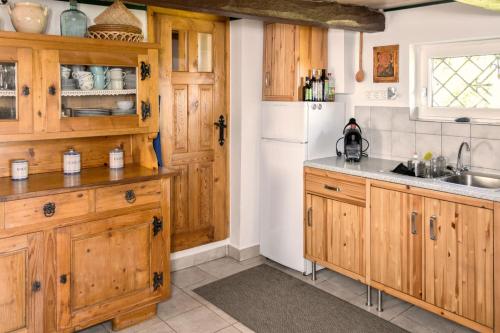 a kitchen with wooden cabinets and a white refrigerator at Kellerstöckl Am Weinberg 140 Gaas in Gaas