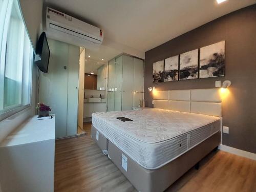 ein Schlafzimmer mit einem großen Bett und einem TV in der Unterkunft Locking's Funcionários 1 in Belo Horizonte