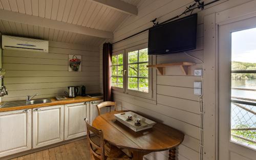 a kitchen and dining room with a table and a tv at Hôtel Quai des Pontis in Cognac