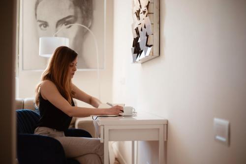 a woman sitting at a table in a room at Cobalto Suite in Campobasso