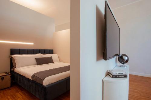 a bedroom with a bed and a flat screen tv at Cobalto Suite in Campobasso