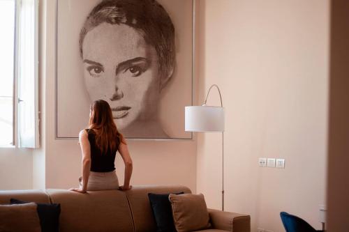 a woman sitting on top of a couch in a living room at Cobalto Suite in Campobasso