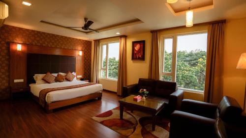 a hotel room with a bed and a couch at National Residency in Mysore