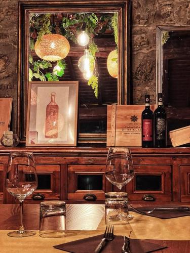 a table with two wine glasses and a mirror at LOCANDA PODERE LE VIGNE in Radda in Chianti