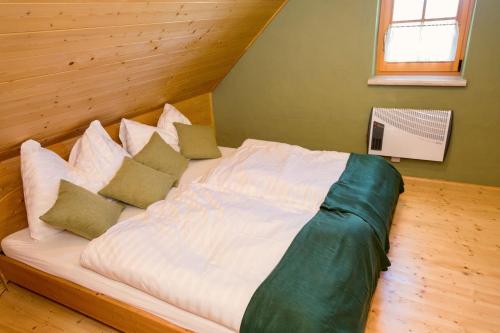 a white bed with pillows in a room at Kellerstöckl Postrumer Weinberg 49 in Kulm im Burgenland
