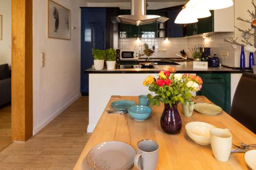 a kitchen with a wooden table with a vase of flowers at Am Bärenbrunnen in Bernkastel-Kues