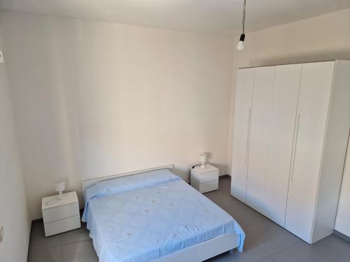 a white bedroom with a bed and two night stands at Pepe's house , a 1 km dal mare in Isca sullo Ionio