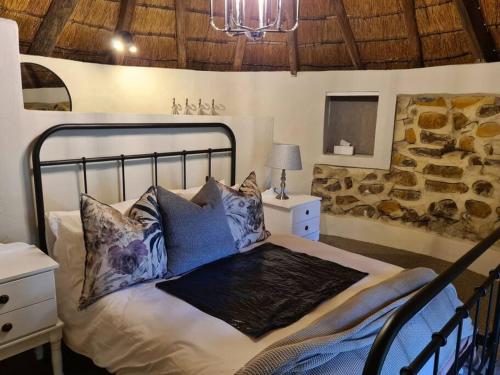 a bedroom with a bed with blue pillows at Burnbrae Farmhouse (6 b/rooms with pool) in Himeville