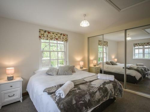 a bedroom with two beds and a large mirror at Home Farm House in Dorrington