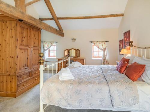 a bedroom with a large bed and wooden cabinets at The Dairy - Uk37518 in Routh