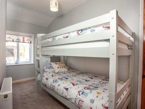 a bedroom with a bunk bed with a white bunk bed at Coastal Haven in Dawlish