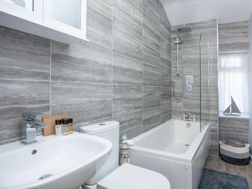 a bathroom with a tub and a toilet and a sink at Coastal Haven in Dawlish
