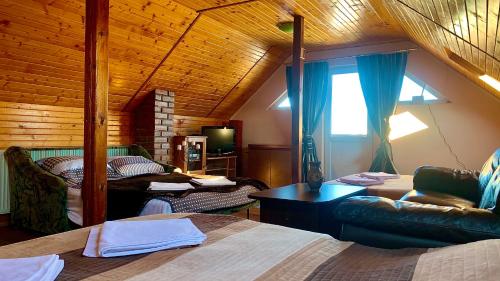 sypialnia z 2 łóżkami i drewnianym sufitem w obiekcie Cabana Plaiuri Ardelene w mieście Petreştii de Jos