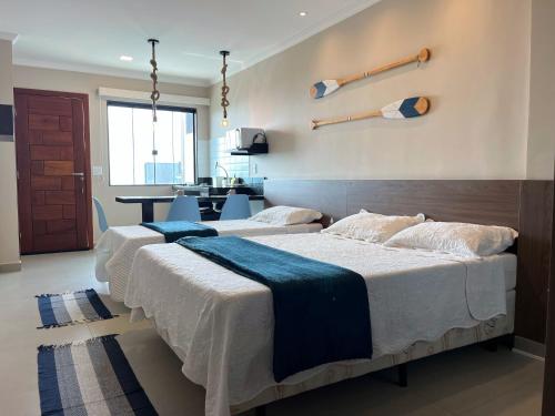 dwa łóżka w pokoju z kuchnią w tle w obiekcie Éolos Loft's - Cabo Frio w mieście Cabo Frio