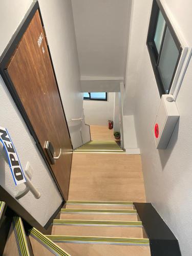 a stairway with a wooden door and a stairwell with a stair at Leisure hotel 中野 in Tokyo