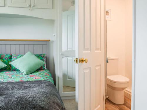 um quarto com uma cama e um WC em Primrose Cottage em Little Rissington