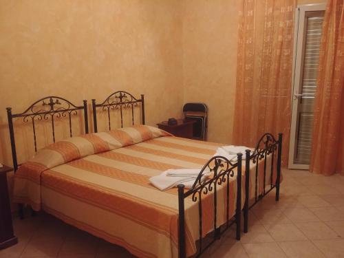 1 dormitorio con 1 cama grande con sábanas de color naranja en PARADISE HOUSE, en Calatabiano
