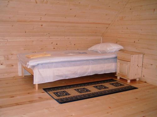 Cama pequeña en habitación con pared de madera en Chalet Sofia, en Borovets