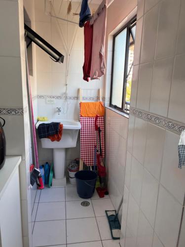 a small bathroom with a sink and a shower at Residencial Michelângelo in Mongaguá