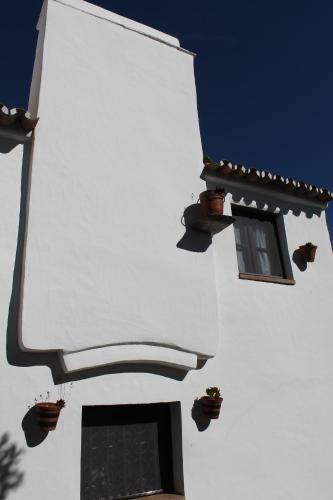 un bâtiment blanc avec deux fenêtres et des plantes en pot dans l'établissement Casa Dom Dinis, à Monsaraz