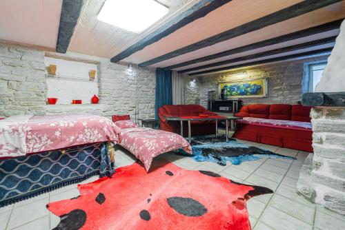 a living room with two beds and a red couch at Videviku Villa Apartments in Tallinn