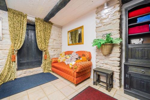 a living room with an orange couch in a house at Videviku Villa Apartments in Tallinn