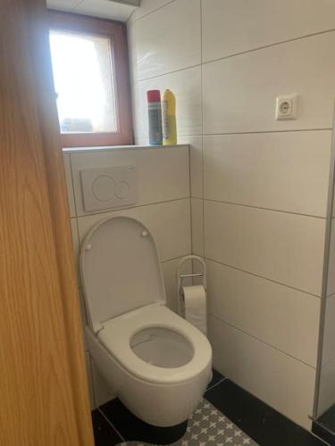 a small bathroom with a toilet and a window at Diyo Apart Festspiel Bayreuth in Bayreuth