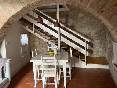une salle à manger avec une table blanche et des escaliers dans l'établissement CASA CELOMMI, à Montepagano