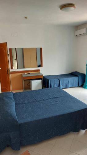 a room with two blue beds and a desk at Hotel Klein Wien in Piano di Sorrento