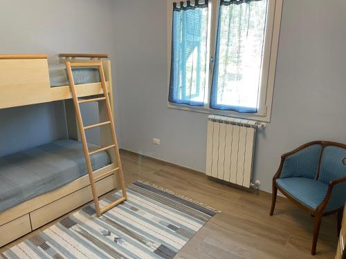 a bedroom with a bunk bed and a chair at Appartamento Luigi in Ventimiglia