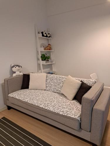 um sofá numa sala de estar com uma parede branca em Woodsbury Suites IKEA House Butterworth Penang em Butterworth