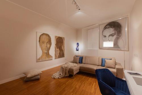 a living room with a couch and pictures on the wall at Cobalto Suite in Campobasso