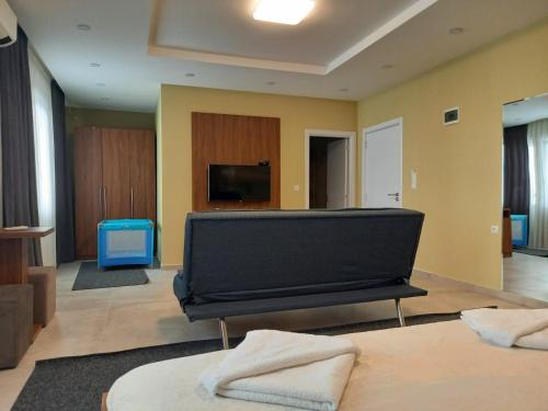 ein Wohnzimmer mit einem Klavier und einem TV in der Unterkunft Hotel Centrum in Mitrovica