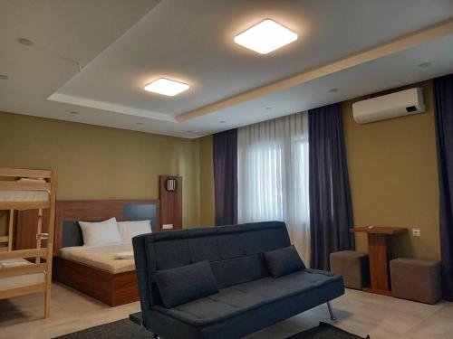 a living room with a couch and a bed at Hotel Centrum in Mitrovicë
