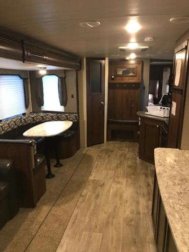 an rv living room with a table and a kitchen at Heartland North Trail 31' RV in Manchaca