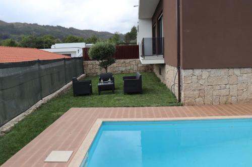 a backyard with a swimming pool and two chairs and a house at Sweet Home in Painzela