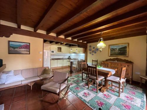 a living room with a table and chairs and a kitchen at Casa El Montero in Espinama