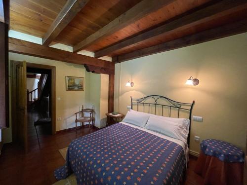 a bedroom with a bed in a room with wooden ceilings at Casa El Montero in Espinama