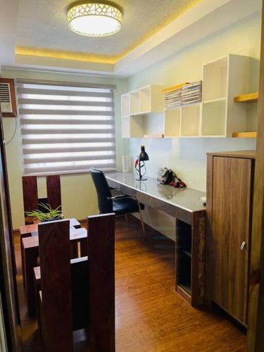 an office with a desk with a chair and a window at 1 Bedroom beautiful condo across Iloilo Esplanade in Iloilo City