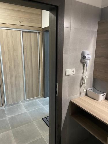 ein Bad mit Dusche und ein Telefon an der Wand in der Unterkunft Apartmán Kapy Lipno in Lipno nad Vltavou